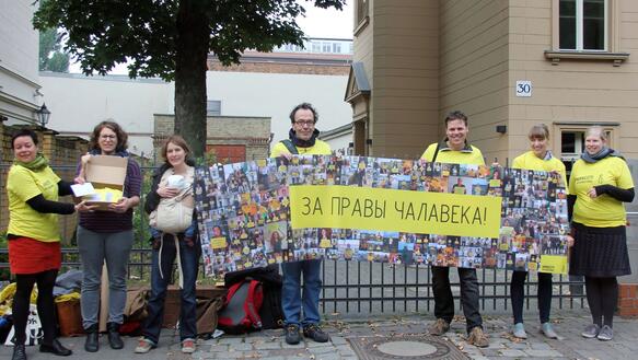 Eine kleine Gruppe steht mit Banner vor der belarussischen Botschaft