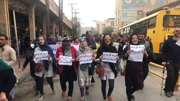 Viele Menschen, in vorderste Reihe vor allem Frauen, demonstrieren mit Bannern und Zetteln auf einer Straße