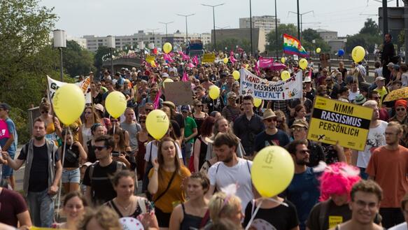 Hunderte Menschen mit Luftballons und Plakaten demonstrieren