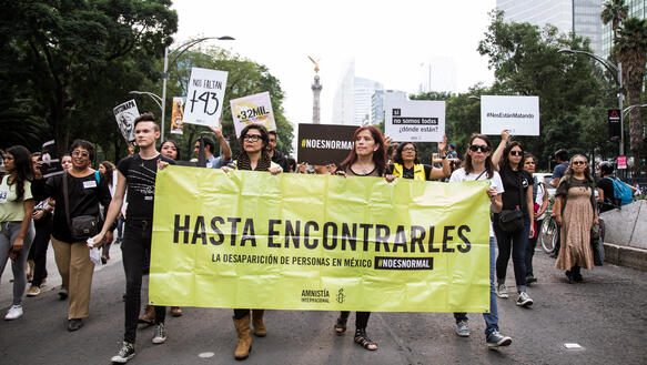 Demonstrationszug mit Amnesty-Transparent, Aufschrift: "Hasta encontrarles"