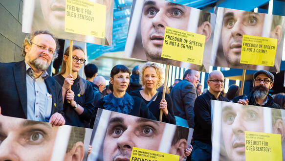 Menschen halten Schilder hoch, um ihre Solidarität mit dem ukrainischen Filmemacher Oleg Sentsov zu bekunden.