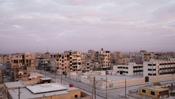 Blick auf die zerschossenen Häuserblöcke einer syrischen Stadt.