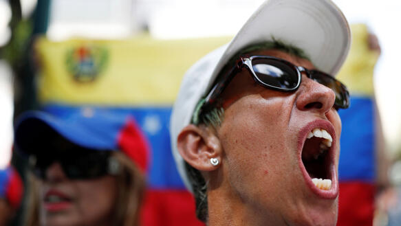 Frau mit Sonnenbrille protestiert, schreit mit weit geöffnetem Mund