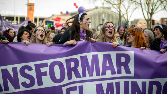 Frauen demonstrieren, singen Slogans, halten ein Plakat