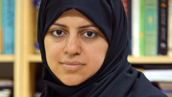 Porträtfoto von Nassima al-Sadah vor einem Bücherregal