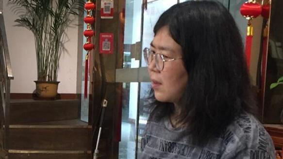 Profilaufnahme einer jungen Frau aus China in dunkler Kleidung.