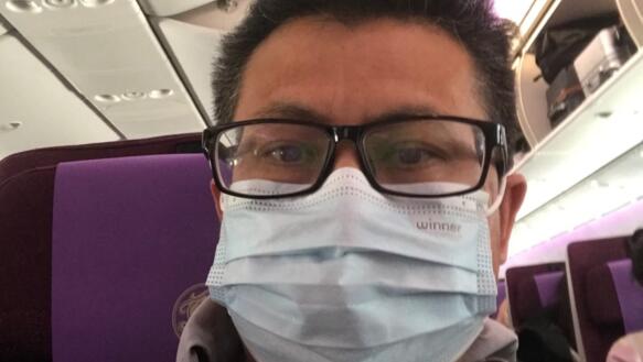 Selfie von Yang Maodong, der auch Guo Feixiong bekannt ist. Er trägt eine Brille und einen Mund-Nase-Schutz. Das Foto wurde auf einem Sitzplatz in einem Flugzeug, Bus oder Zug aufgenommen.