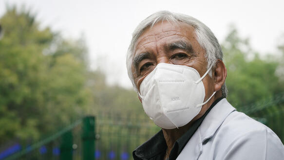 Porträt von Jorge Pérez Ortega, der eine FFP-2-Maske trägt und an der Kamera vorbei schaut.