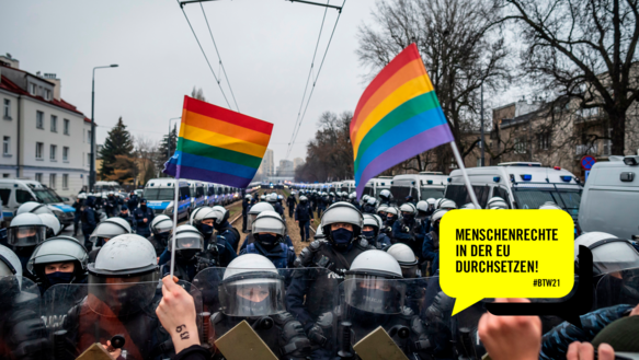 Viele Polizisten in Schutzausrüstung mit Helmen. Im Vordergrund sieht man Hände, die ihnen zwei Regenbogenflaggen entgegen strecken. Rechts unten in der Ecke eine gelbe Sprechblase, darin steht in schwarzer Schrift: Menschenrechte in der EU durchsetzen! #BTW21