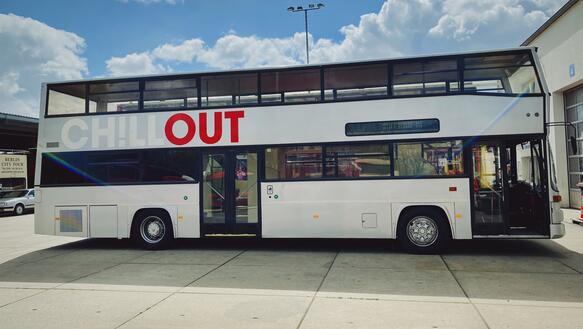 Das Bild zeigt einen grauen Doppel-Decker-Bus in der Seitenansicht