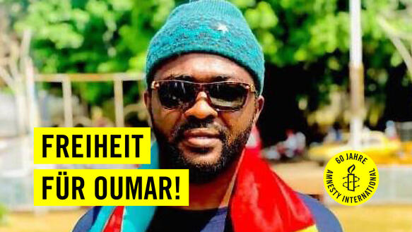 Ein Mann mit Sonnenbrille und Mütze. Auf gelben Balken steht in schwarzer Schrift: Freiheit für Oumar! Auf einem gelben Kreis ist eine Kerze, die von Stachesdraht umschlungen wird, zu sehen und es steht "60 Jahre Amnesty International" geschrieben. 