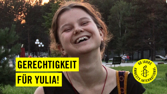 Eine junge Frau hat ihren Kopf zurückgelegt und lacht. Auf gelben Balken steht in schwarzer Schrift "Gerechtigkeit für Yulia!" und auf einem gelben Kreis ist eine schwarze Kerze, die von Stacheldraht umschlängelt wird und in schwarzer Schrift steht "60 Jahre Amnesty International" geschrieben.