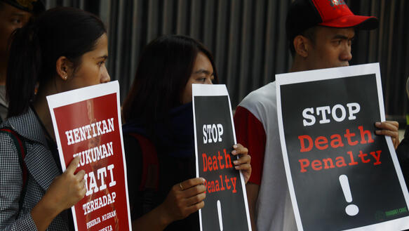 Das Bild zeigte eine Demonstration mit mehreren Personen, sie halten Schilder in der Hand "Stop Death Penalty"