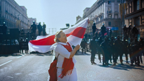 Das Bild zeigt eine Frau mit einer weiß-roten Fahne