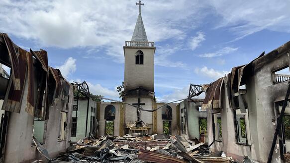 Das Foto zeigt die bis auf die Grundmauern niedergebrannte Ruine einer Kirche.