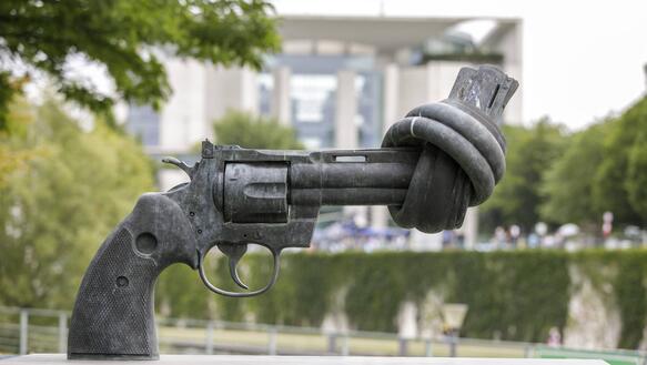 Das Bild zeigt die Skulptur einer verknoteten Pistole