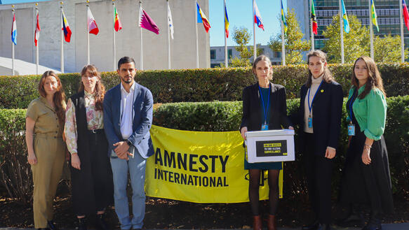 Das Bild zeigt mehrere Personen vor einem Amnesty-Banner