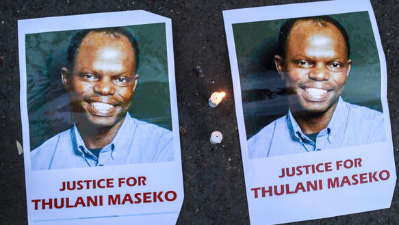 Das Bild zeigt Plakate mit den Porträtfotos eines Mannes, darunter steht "Justice for Thulani Maseko"