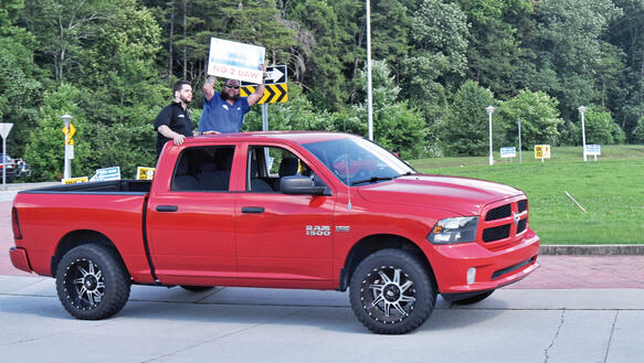 Männer auf der Ladefläche eines Pick-ups demonstrieren gegen eine Gewerkschaftsgründung bei VW, einer von ihnen hält ein Schild in die Höhe, auf dem steht "NO 2 UAW"