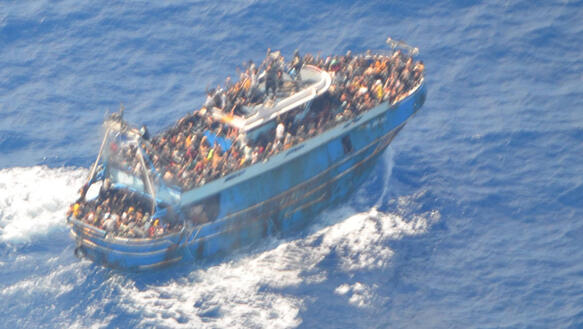 Das Bild zeigt ein überladenes Schiff mit hunderten Menschen aus der Vogelperspektive