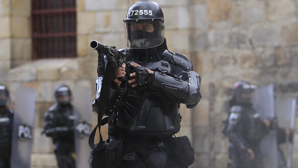 Das Bild zeigt einen schwer bewaffneten Polizisten