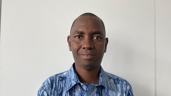 Der Direktor von Amnesty Guinea, Souleymane Sow, im Porträt, ein junger Mann mit milimeterkurzem Haar, der ein Hemd trägt.