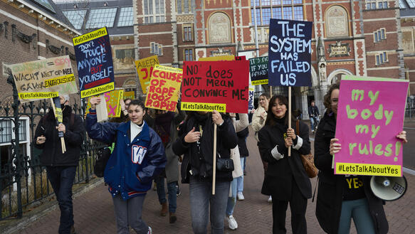Das Bild zeigt mehrere Menschen mit Protestplakaten
