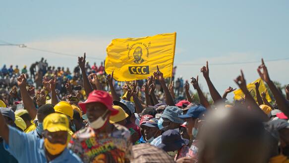 Demonstreirende Menschen, in der Mitte eine gelbe Fahne mit der Aufschrift „CCC“
