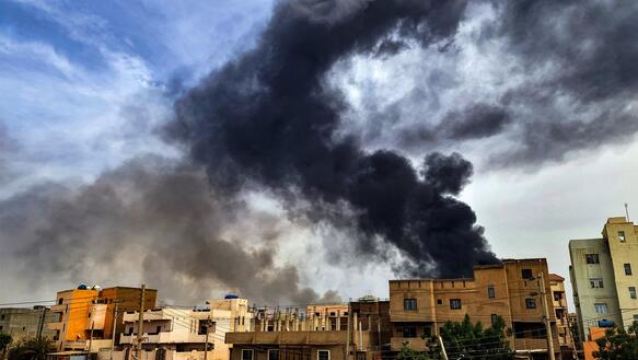 Über mehreren Häusern in der sudanesischen Hauptstadt Khartum steigen schwarze und graue Rauchschwaden auf.