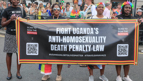 Vier Personen halten während einer Demonstration ein Banner vor sich, auf dem unter anderem steht: "Fight Uganda's Anti-Homosexuality Death Penalty Law".
