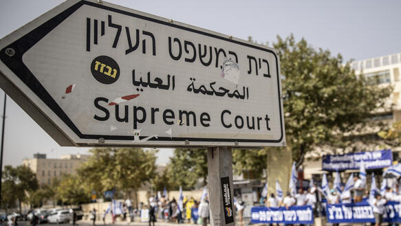 Das Bild zeigt ein Straßenschild auf dem steht: "Supreme Court"