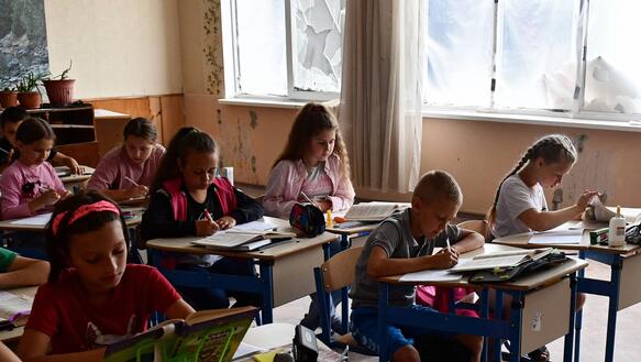 Das Bild zeigt mehrere Schülerinnen und Schüler in einem Klassenzimmer