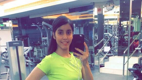 Das Bild zeigt das Selfie einer jungen Frau im Fitnessstudio