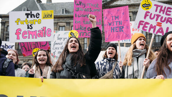 Das Bild zeigt viele Menschen mit Protestplakaten