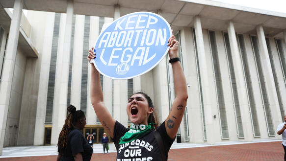Eine Frau hält ein Schild hoch auf dem steht: "Keep abortion legal". 