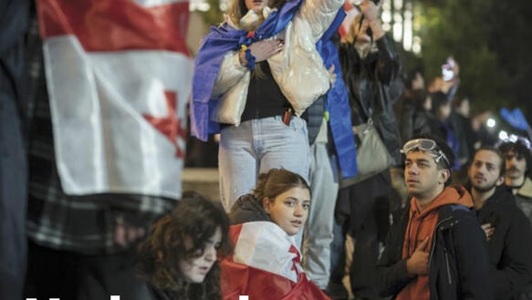 Georgische Jugendliche stehen auf einer Straße, sie tragen teilweise die Landesflagge um die Schultern, sie protestieren. Darüber das Logo des Journals und der Titel "Verkremlt euch!"