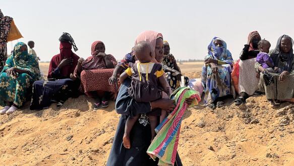 Frauen und Kinder sitzen auf dem Boden