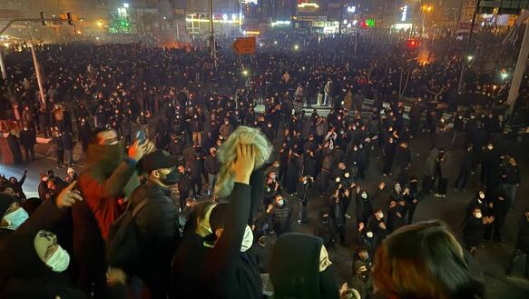 Große demonstrierende Menschenmenge auf einem Platz.
