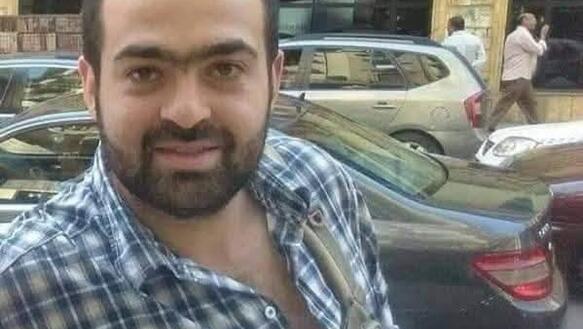Porträtbild von Mohamed Adel. Er lächelt in die Kamera, hat kurze schwarze Haare