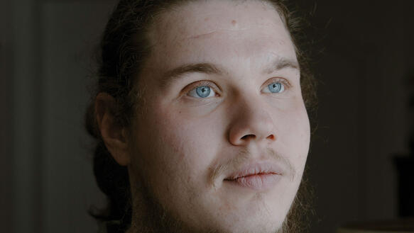 Ein junger ukrainischer Mann mit Bart in einer Soldatenuniform.