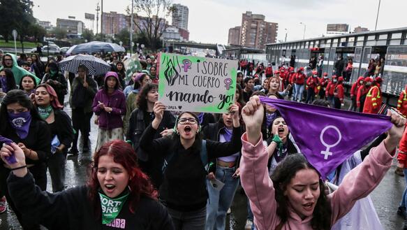 Frauen bei einem Demonstrationszug mit feministischen Plakaten und Symbolen