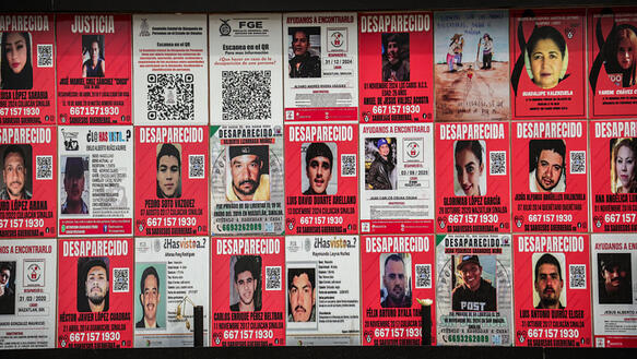Das Foto zeigt eine Mauer oder Wand, die komplett verdeckt ist mit steckbriefartigen Plakaten.