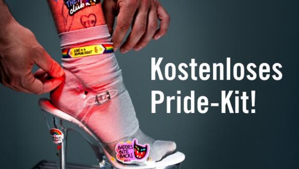 Ein Fuß in einem High Heel dekoriert mit dem Amnesty Internatioanl Deutschland Pride Kit 2026