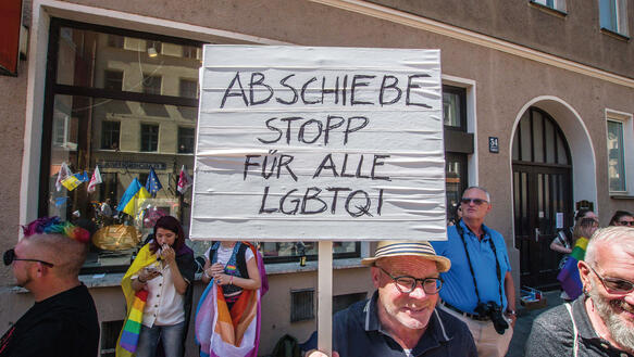 Person auf dem CSD in München 2022 mit Schild in der Hand "Abschiebestopp für alle LGBTQI"