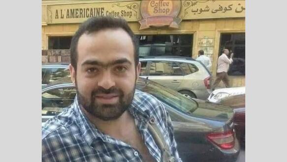 Porträtbild von Mohamed Adel. Er lächelt in die Kamera, hat kurze schwarze Haare