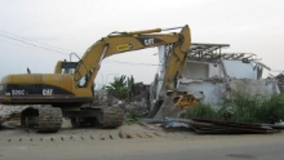 Ein Bagger zerstört Häuser in Port Harcourt, Nigeria, April 2010