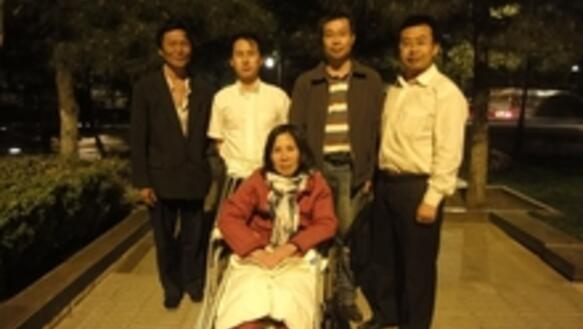 Anwaltskollegen besuchen die im Rollstuhl sitzende Ni Yulan und ihren Ehemann Dong Jiqin (links)