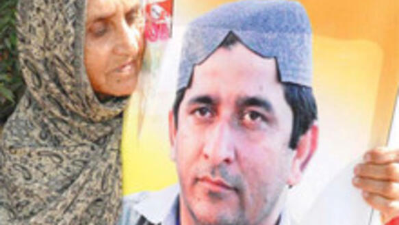 Mutter hält Plakat mit Muzaffar Bhutto