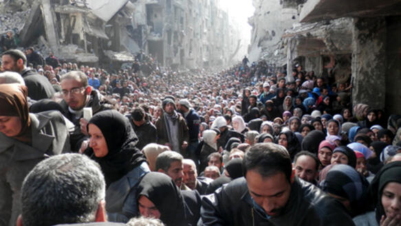 Die Einwohner Yarmouks warten auf die Essenvergabe durch Hilfsorganisationen