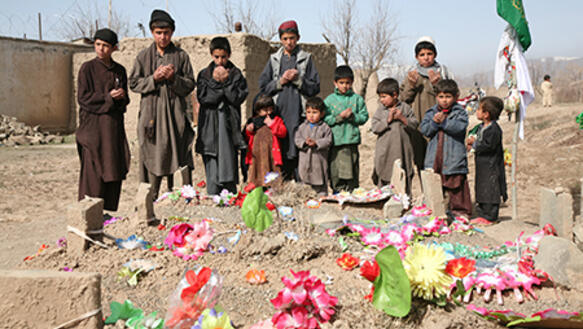 Betende Kinder vor einem Grab: "Tausende Afghanen sind seit 2001 von US-Soldaten getötet oder schwer verletzt worden."